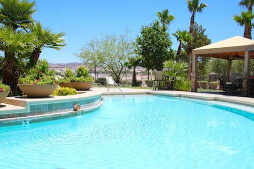 A pool surrounded by palm trees and a gazebo at Avalon at Seven Hills Apartments, Henderson