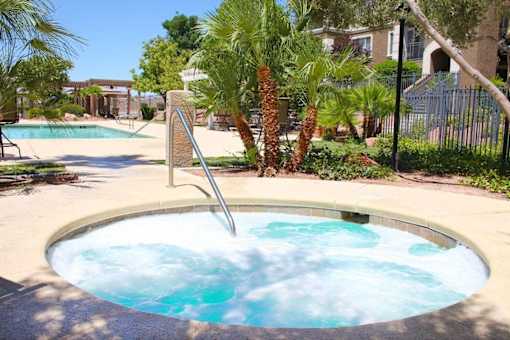 A hot tub in the middle of a pool surrounded by palm trees at Avalon at Seven Hills Apartments, Nevada, 91790