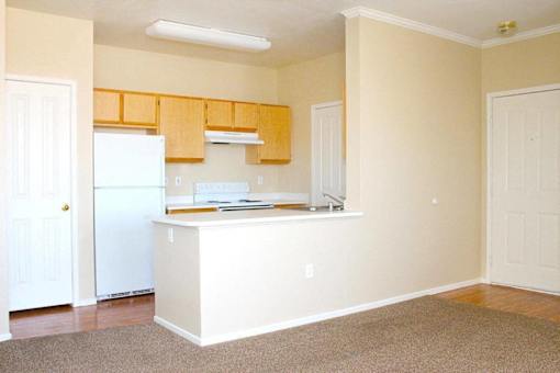 A kitchen with white appliances and wooden cabinets at Avalon at Seven Hills Apartments, Henderson, 91790