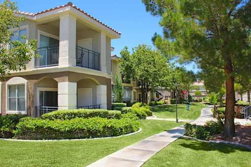 A building with a balcony and a green lawn in front at Avalon at Seven Hills Apartments, Nevada