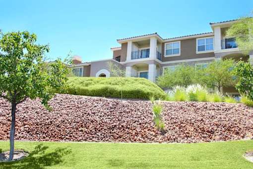 A large building with a green lawn in front at Avalon at Seven Hills Apartments, Henderson, NV, 91790
