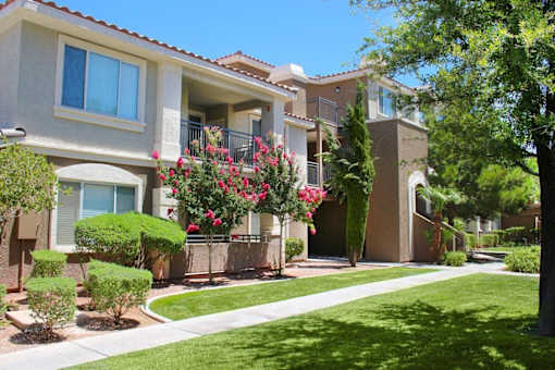 Apartment complex with green bushes and trees at Avalon at Seven Hills Apartments, Henderson, Nevada