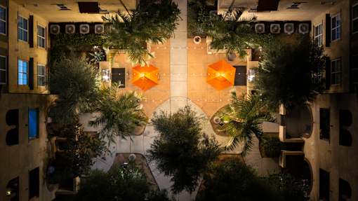 A view of a courtyard from above with plants and orange decorations.