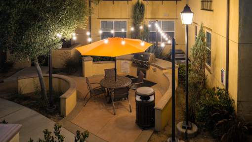 A patio with a table and chairs under an umbrella.