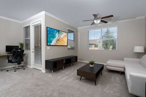 A living room with a flat screen TV mounted on the wall.