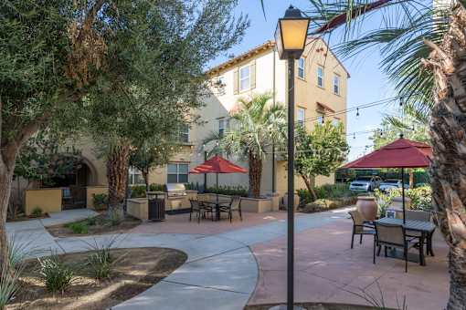 A sunny day at the outdoor seating area of a restaurant with tables and chairs.