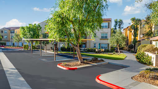 an empty parking lot in front of an apartment building