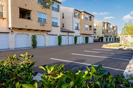 an empty parking lot in front of an apartment building
