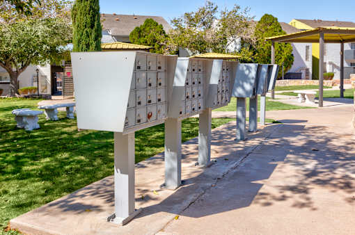 A series of white mailboxes are lined up on a sidewalk.