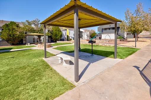 A canopy structure is situated in a grassy area.