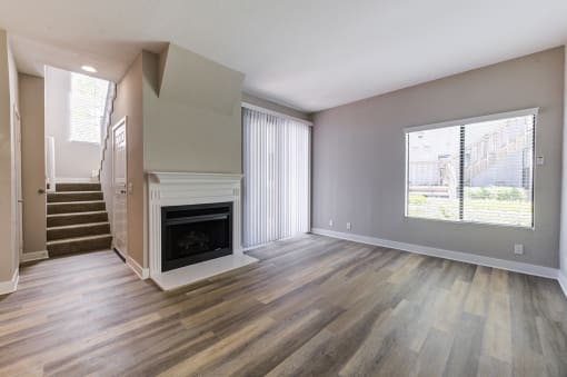 Living area with sliding glass doors to balcony, windows, and fireplace adjacent to stairs at Pointe Niguel, Laguna Niguel