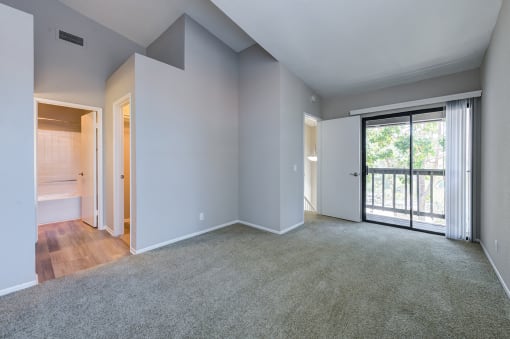 One Bedroom Apartments in Laguna Niguel CA - Pointe Niguel - Empty Bedroom with Carpeted Floor, Gray Walls, and Sliding Glass Door with Access to Balcony at Pointe Niguel, Laguna Niguel