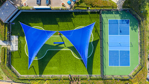 A tennis court with a blue shade structure.