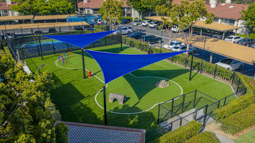 A blue shade structure is over a small soccer field.