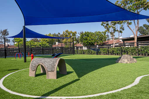 A playground with a blue canopy and a white pathway.