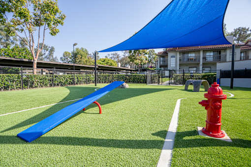 A blue shade structure is over a playground.