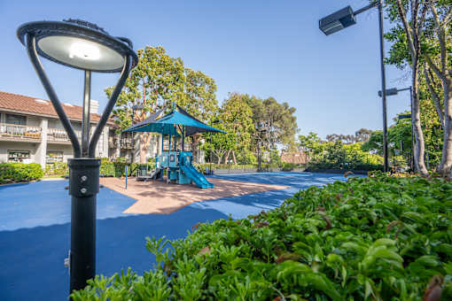 A playground with a blue slide and a green canopy.