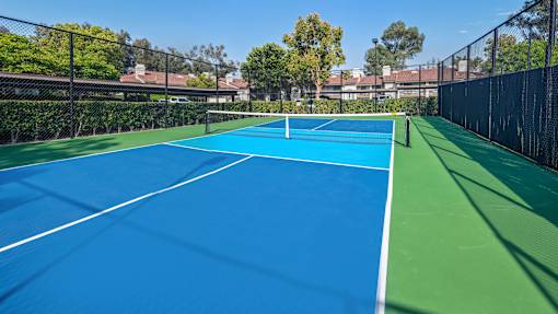 A tennis court with a blue surface and white lines.