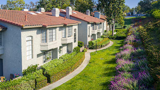A row of houses with a green lawn in front.