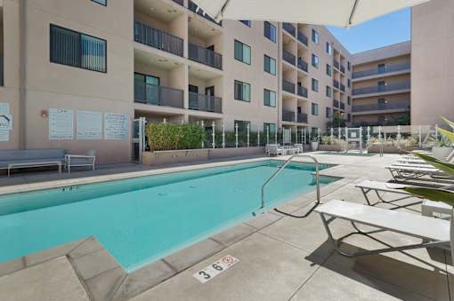 A pool area with a pool and sun loungers at Wilshire Valencia Apartment, California