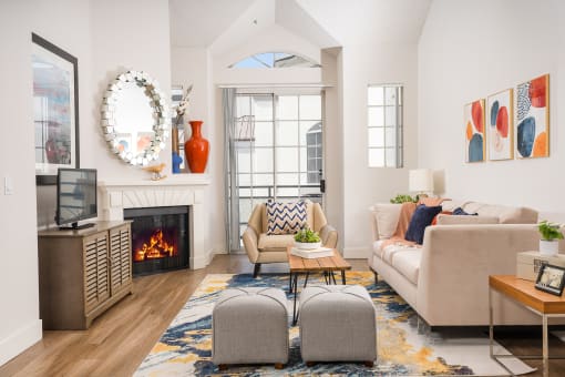 Living room with a large window and a wooden floor at The Preston Miracle Mile Apartments, Los Angeles, CA