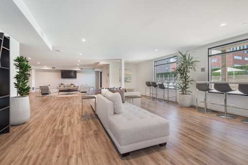 A modern living room with a white sofa and wooden floors at Wilshire Valencia Apartment, California, 90017