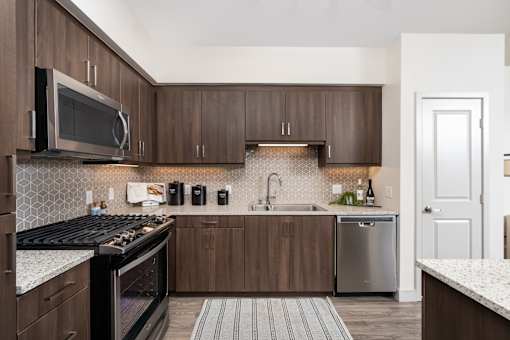 A kitchen with a black stove top oven and a black and white tiled backsplash.