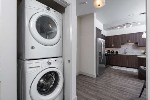 A white front loading washing machine is in a laundry room.