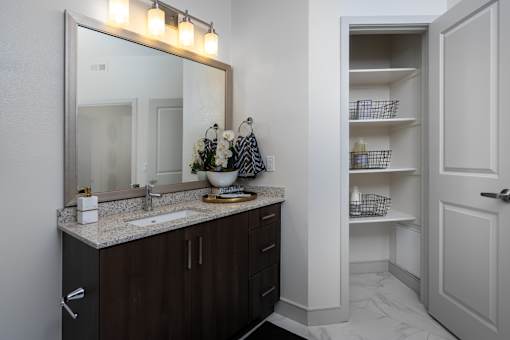 A bathroom with a sink, mirror, and cabinet.