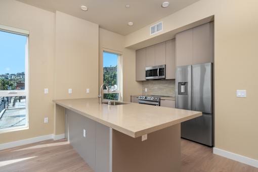 A kitchen with a large island and stainless steel appliances. at Skyview Sunset, Los Angeles, CA