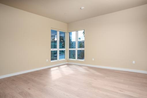 Empty room with wooden floors and a large window. at Skyview Sunset, Los Angeles, CA