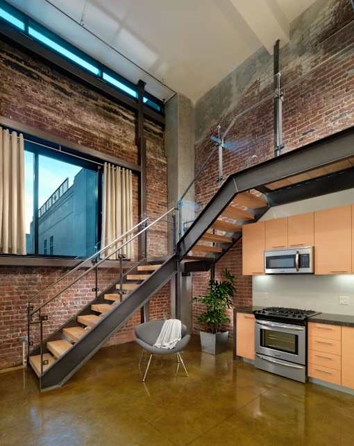 A modern kitchen with a staircase leading to the upper floor.at Arc Light, San Francisco, CA 94107 