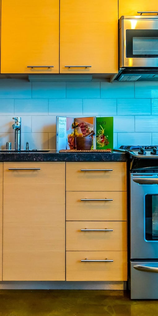A kitchen with a black counter top and white cabinets.at Arc Light, California, 94107