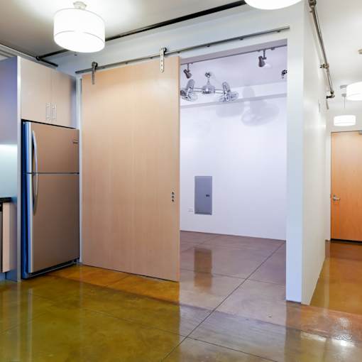 A kitchen with a refrigerator and a wooden door.at Arc Light, San Francisco