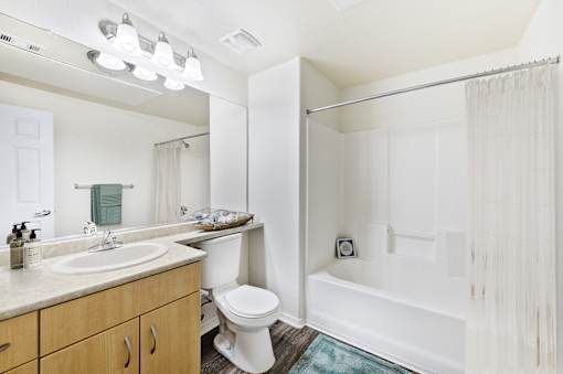 A white bathroom with a toilet, sink, and bathtub.