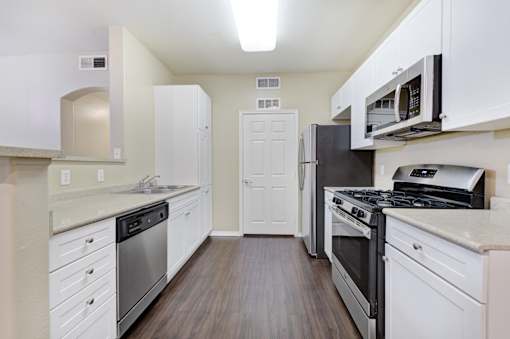 A kitchen with white cabinets and stainless steel appliances.