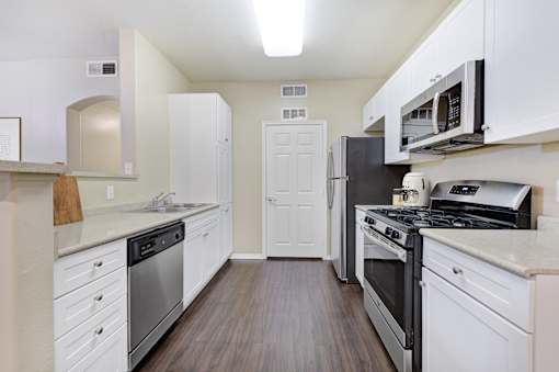 A kitchen with white cabinets and stainless steel appliances.