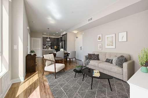 1 Bedroom Modern Apartments in Long Beach, CA - Urban Village - Living Room with Vinyl Plank Flooring, Area Rug, Sofa, Armchair, Coffee Table, and Large Windows.