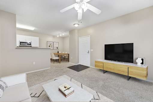 A living room with a television, a chair, a table, and a book on the coffee table.