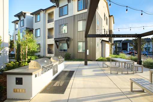 A modern building with a white and brown exterior and a walkway in front.