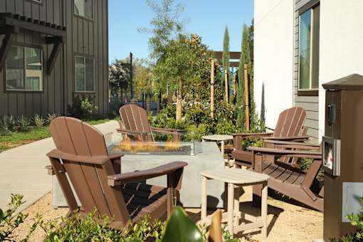 A patio with chairs and a fire pit.