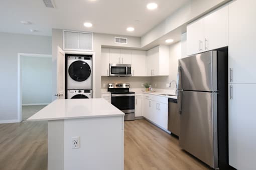 A modern kitchen with a refrigerator on the right.