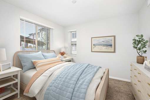 A bedroom with a bed, nightstand, and a painting on the wall.
