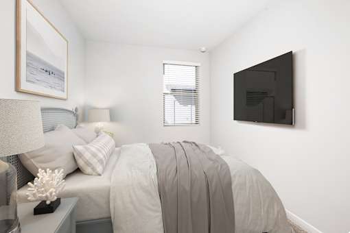 A bedroom with a bed, nightstand, lamp, and a painting on the wall.