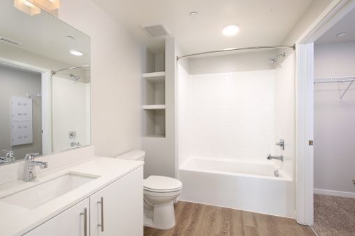 A white bathroom with a sink, toilet, and bathtub.