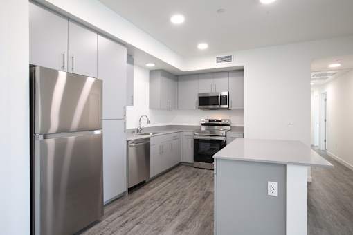 A modern kitchen with stainless steel appliances and a center island.