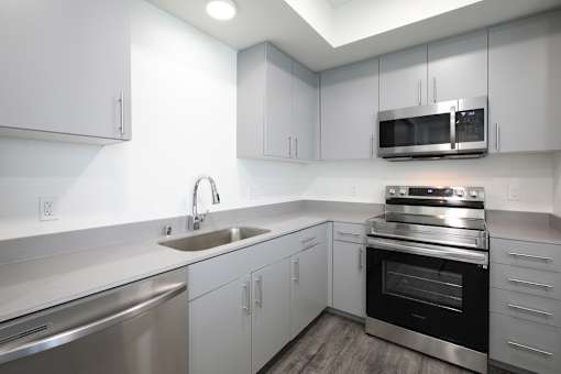 A modern kitchen with stainless steel appliances and white cabinets.