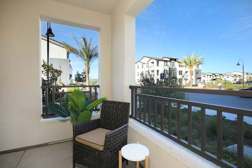 A balcony with a chair and a table.
