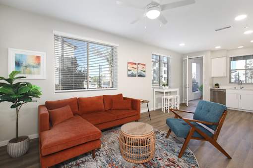 A living room with a red couch and a blue chair.