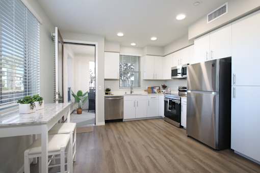 A modern kitchen with white cabinets and stainless steel appliances.